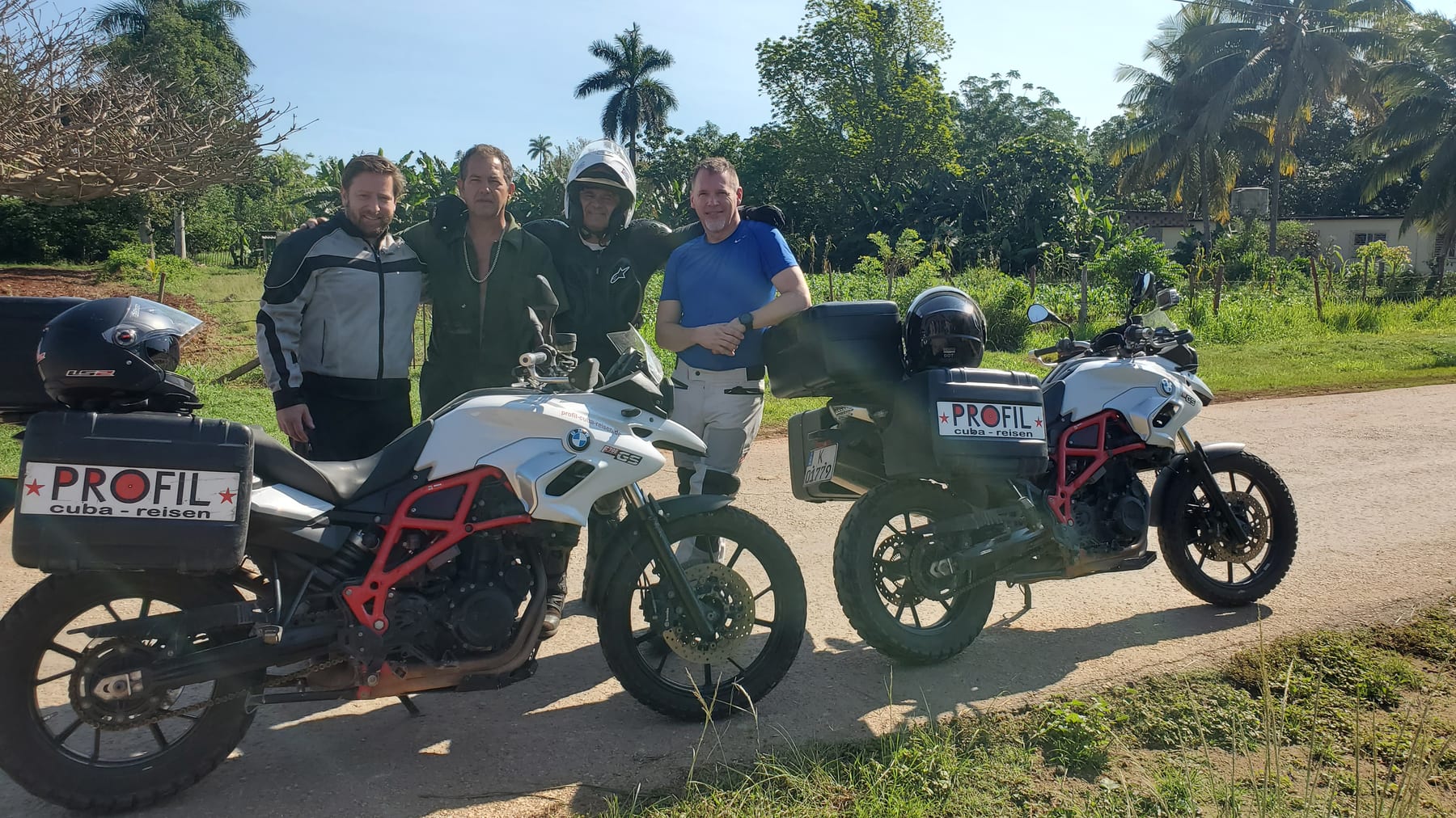 Riders standing beside adventure motorcycles in Cuba